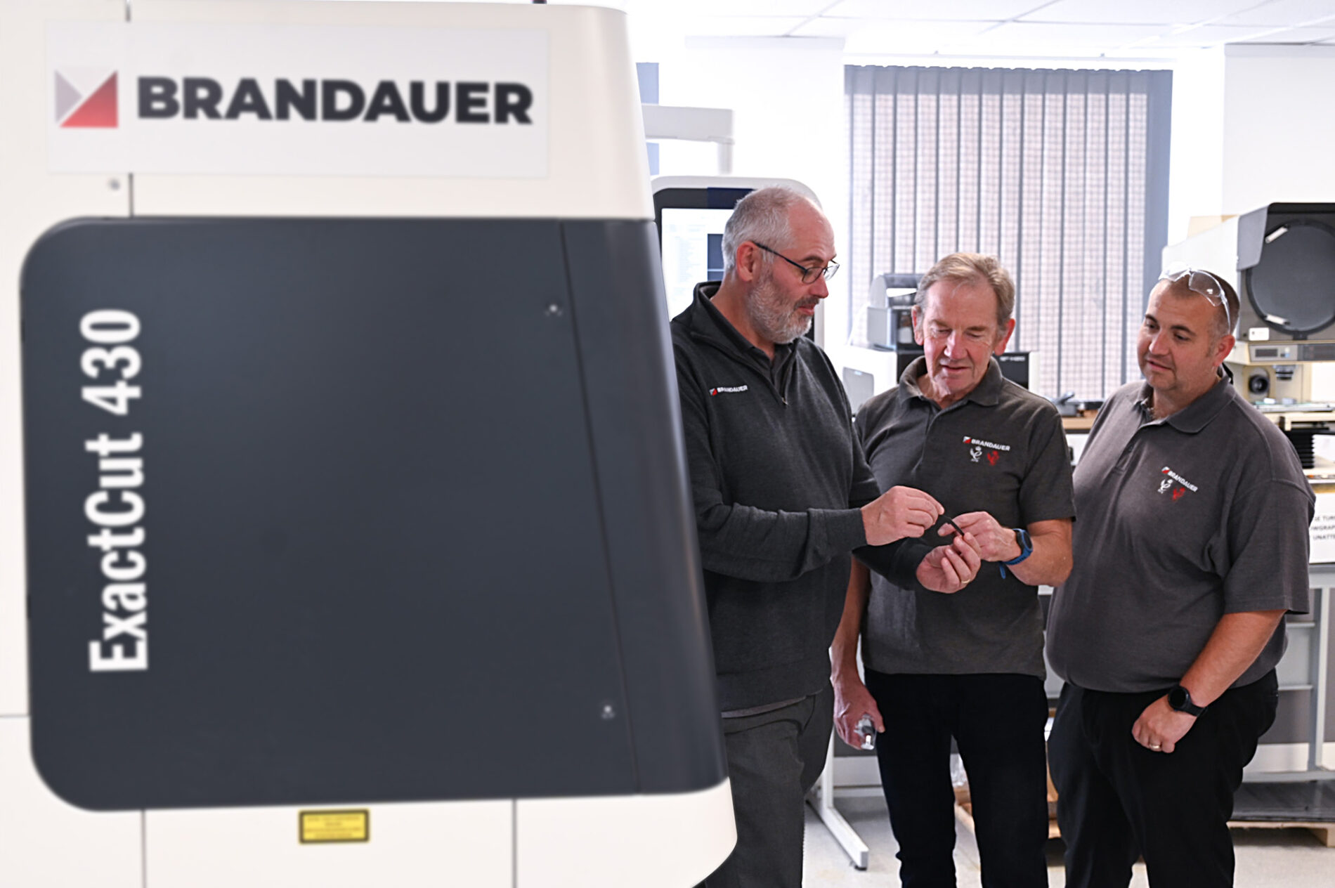 Brandauer post-MBO - team looking at a product